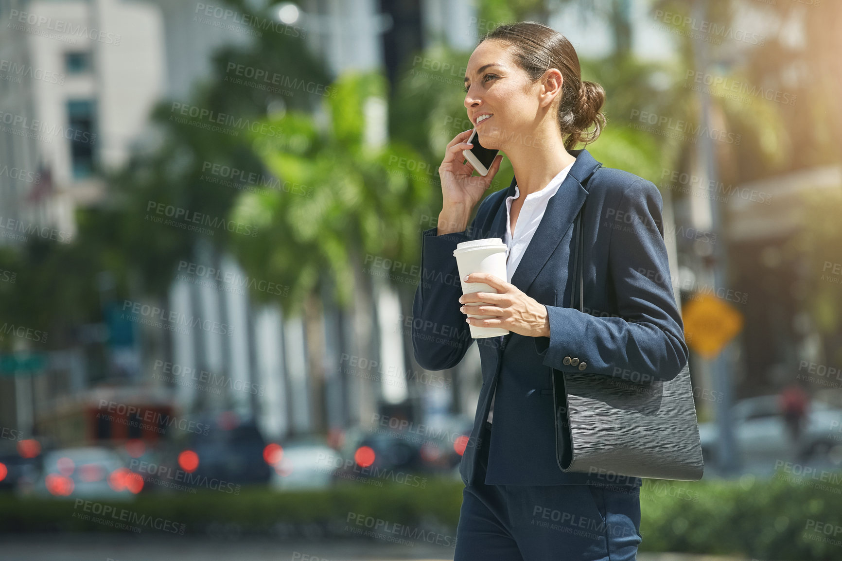 Buy stock photo Shot of a young businesswoman talking on her phone while out in the city