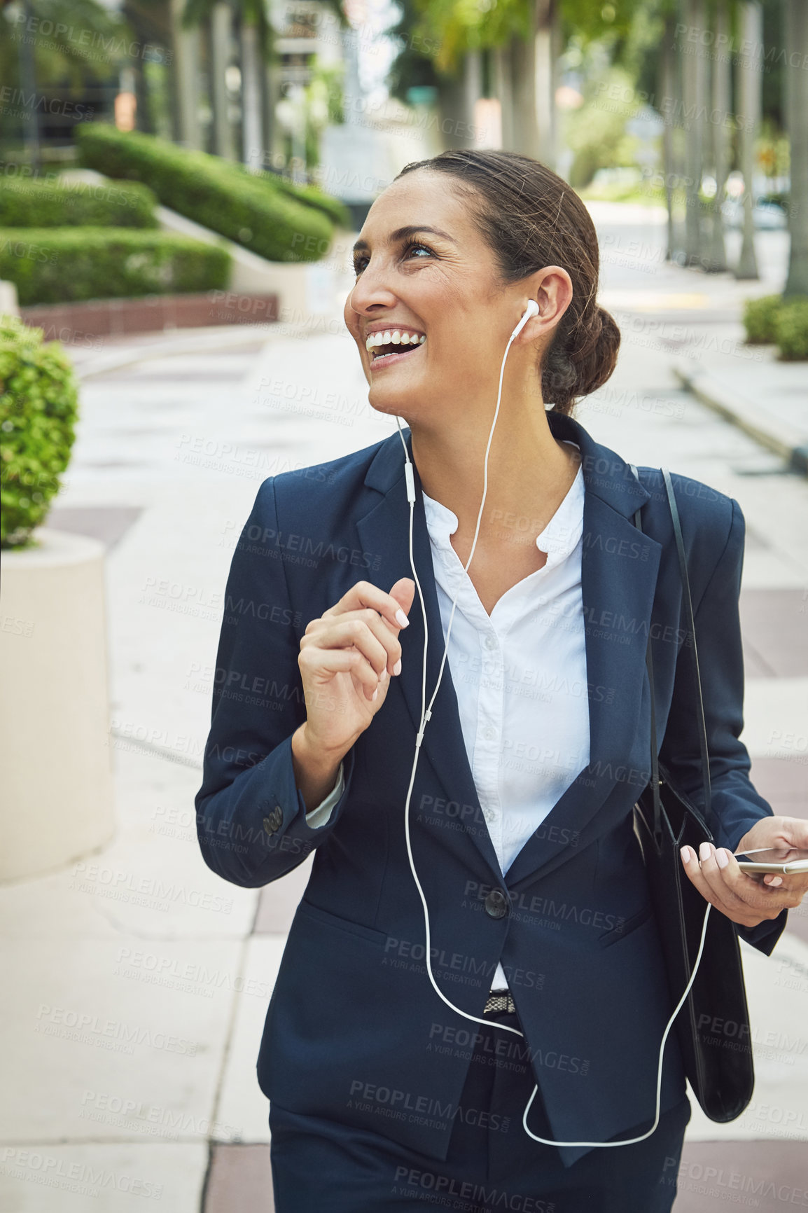 Buy stock photo Shot of a young businesswoman talking on her phone while out in the city