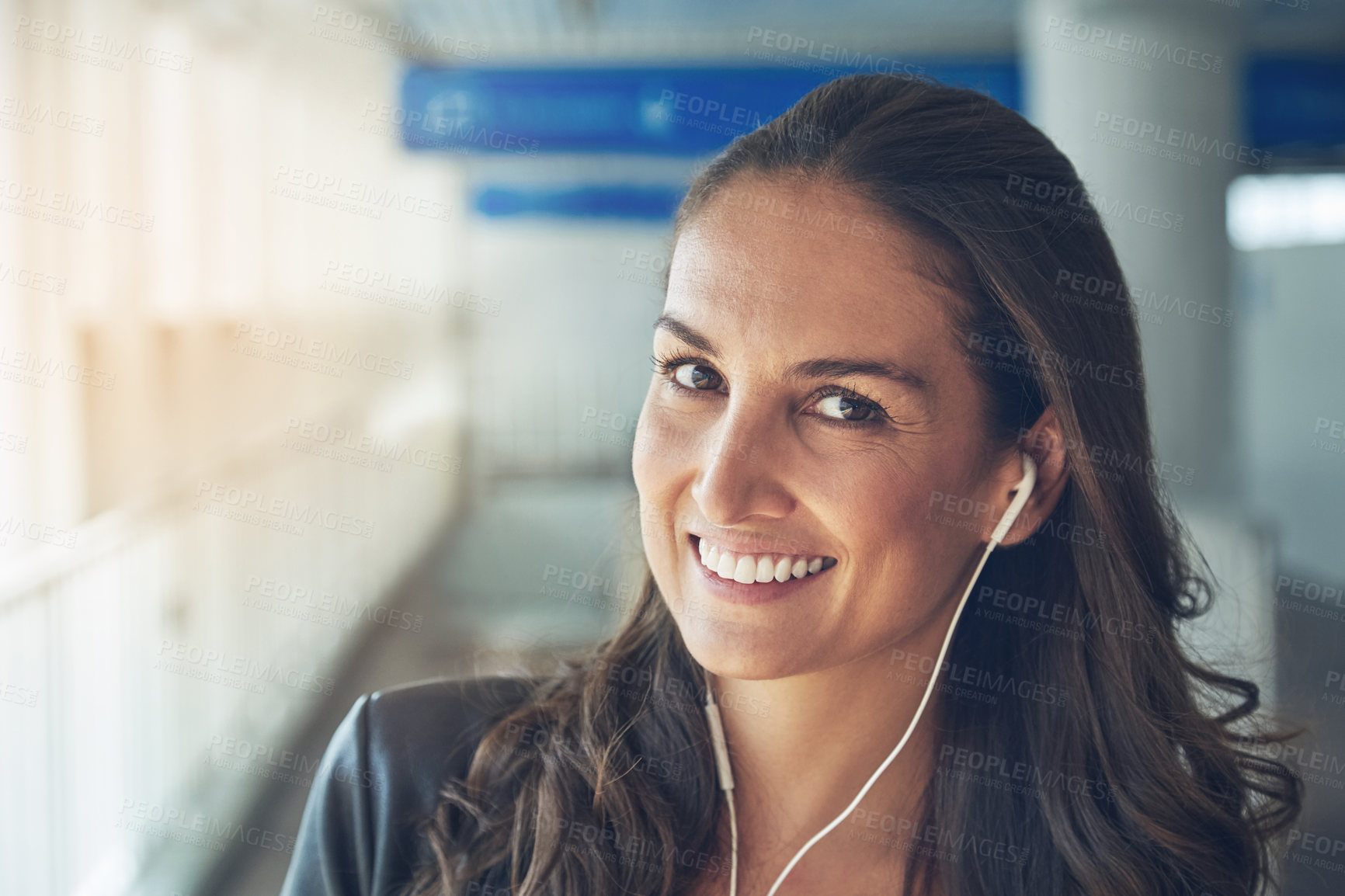 Buy stock photo Portrait of a young woman with earphones on in an urban setting