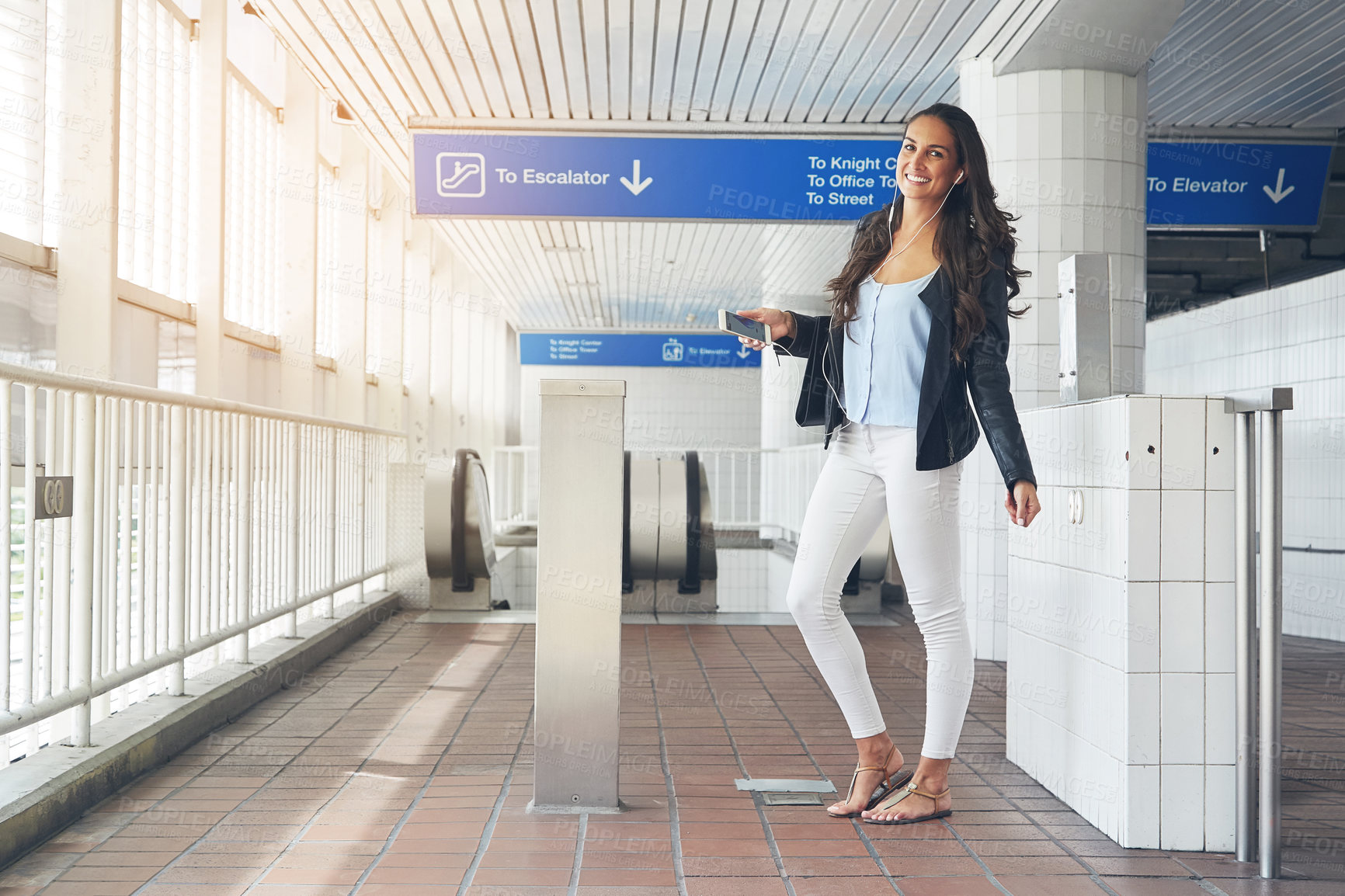 Buy stock photo Shot of a young woman dancing to music on a phone in an urban setting