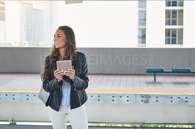 Buy stock photo Shot of a young woman using a digital tablet at a train station