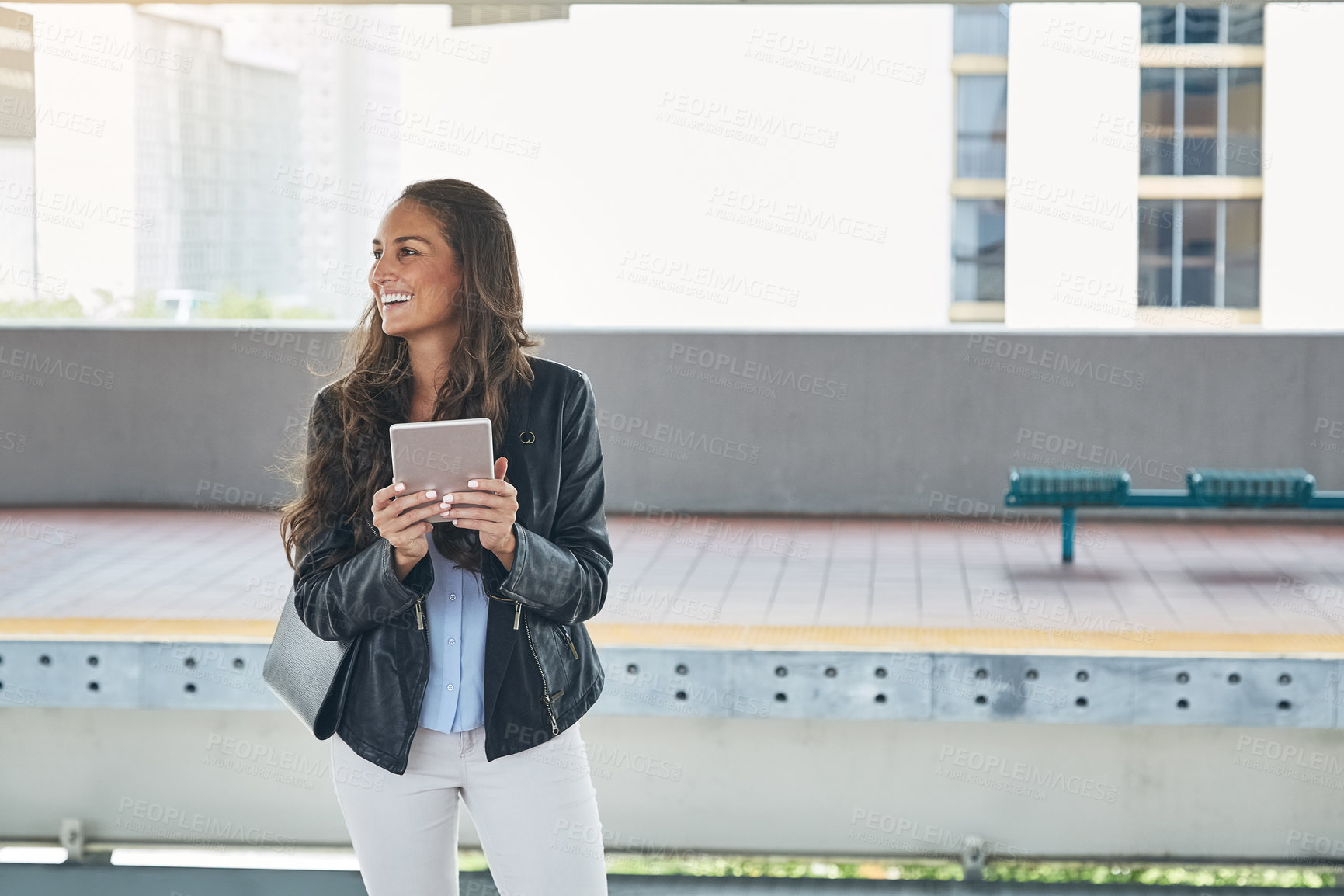 Buy stock photo Shot of a young woman using a digital tablet at a train station