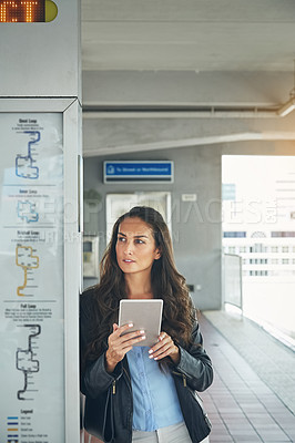 Buy stock photo Shot of a young woman using a digital tablet at a train station