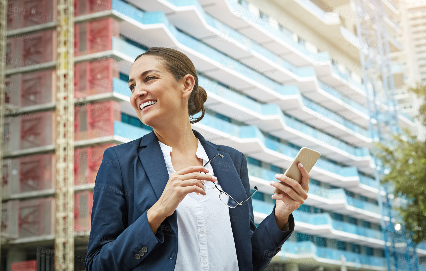 Buy stock photo Shot of a young businesswoman using her phone while out in the city