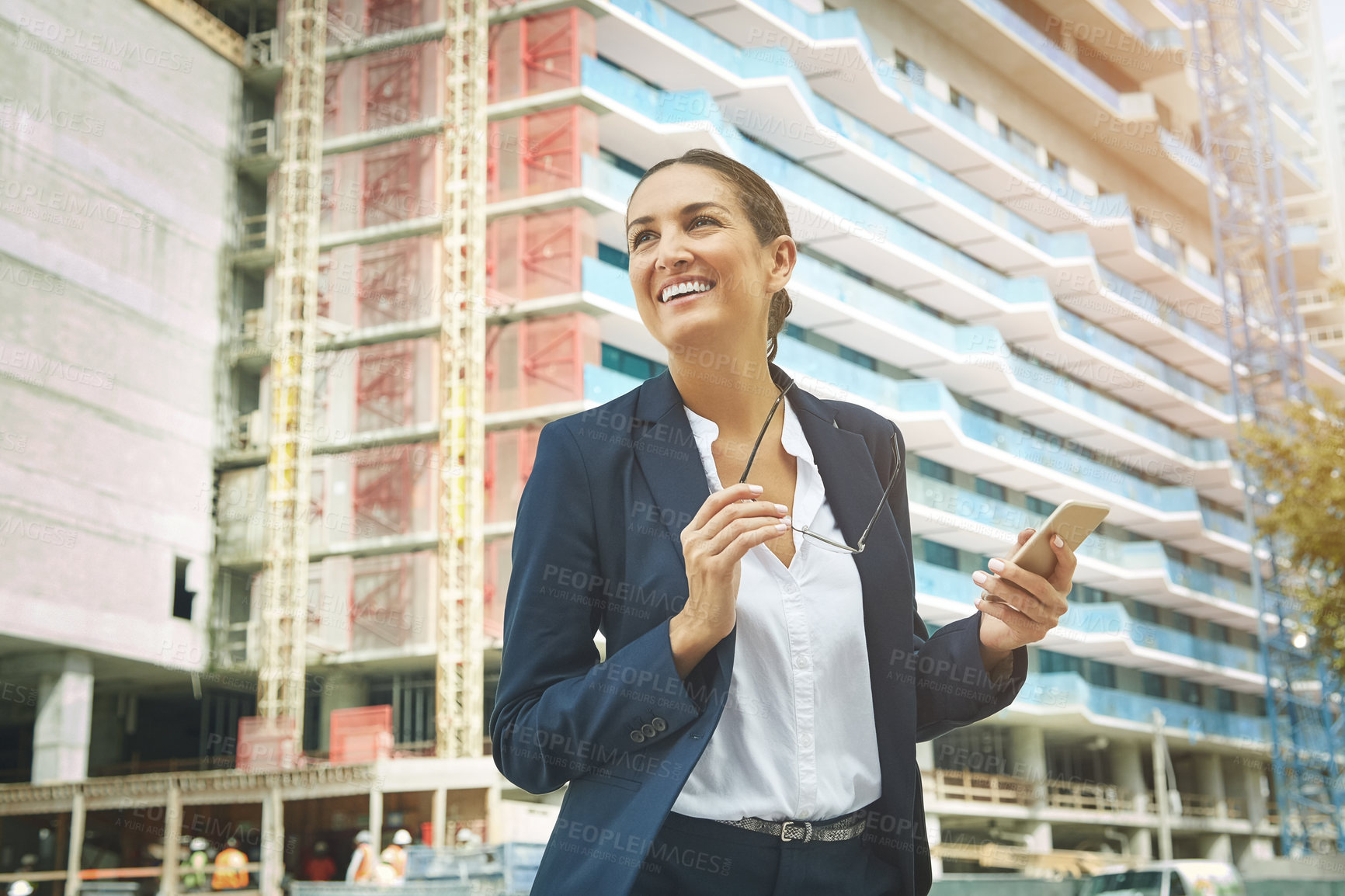 Buy stock photo Shot of a young businesswoman using her phone while out in the city