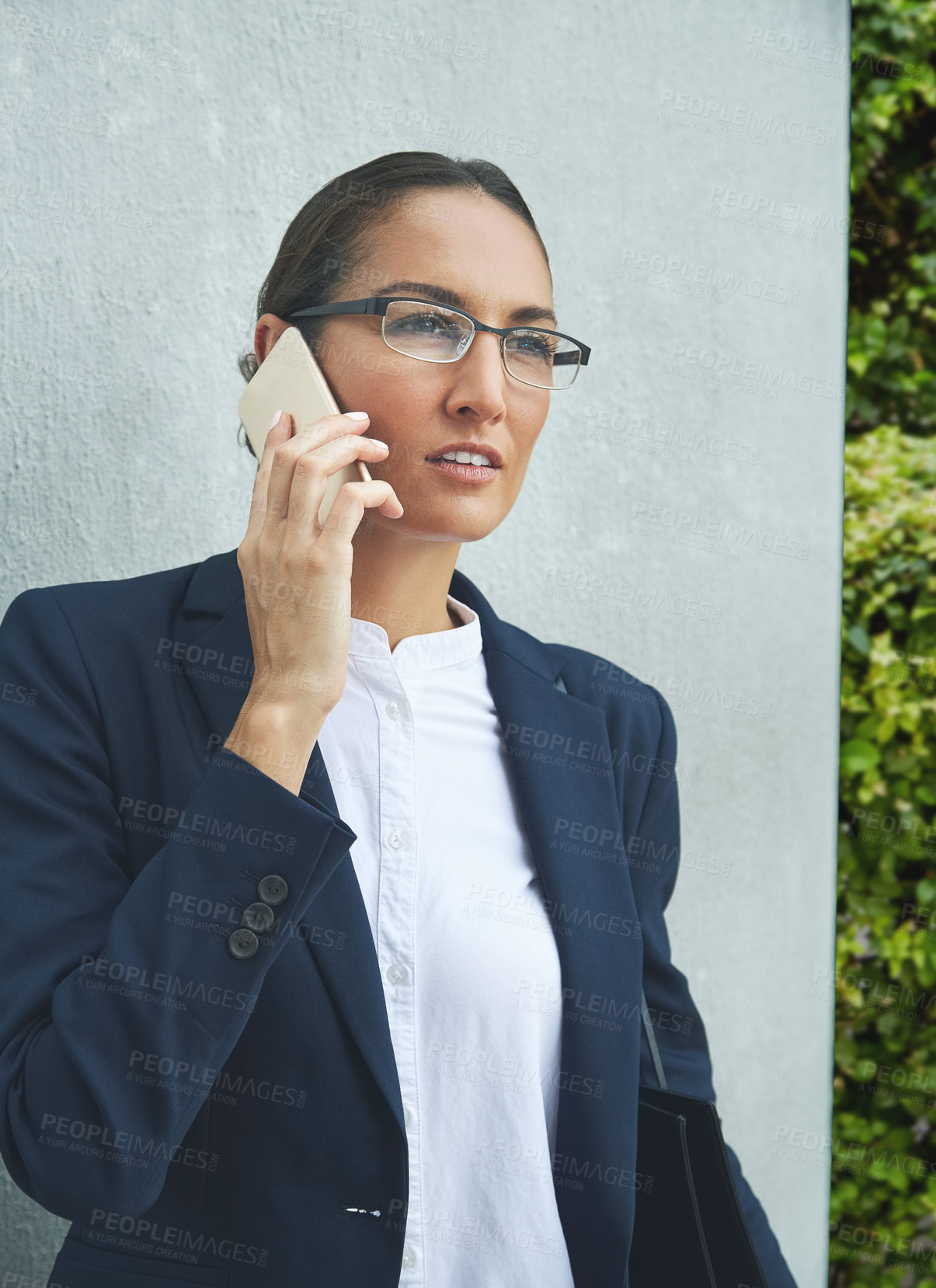 Buy stock photo Shot of a young businesswoman talking on her phone outdoors