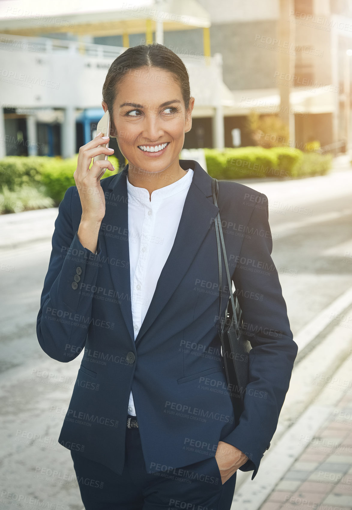 Buy stock photo Shot of a young businesswoman talking on her phone while out in the city