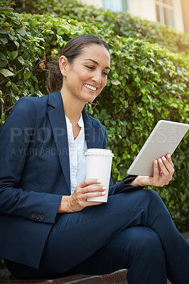 Buy stock photo Shot of a young businesswoman using her digital tablet while out in the city