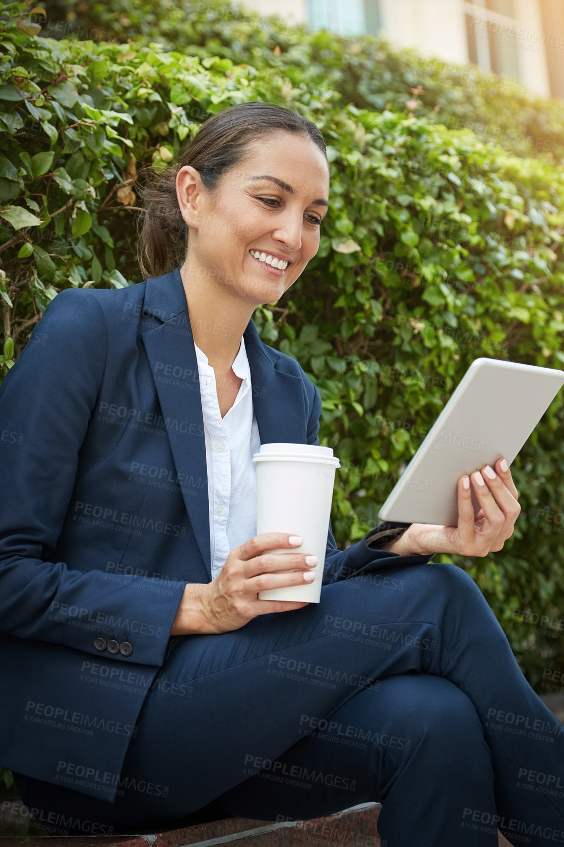 Buy stock photo Shot of a young businesswoman using her digital tablet while out in the city