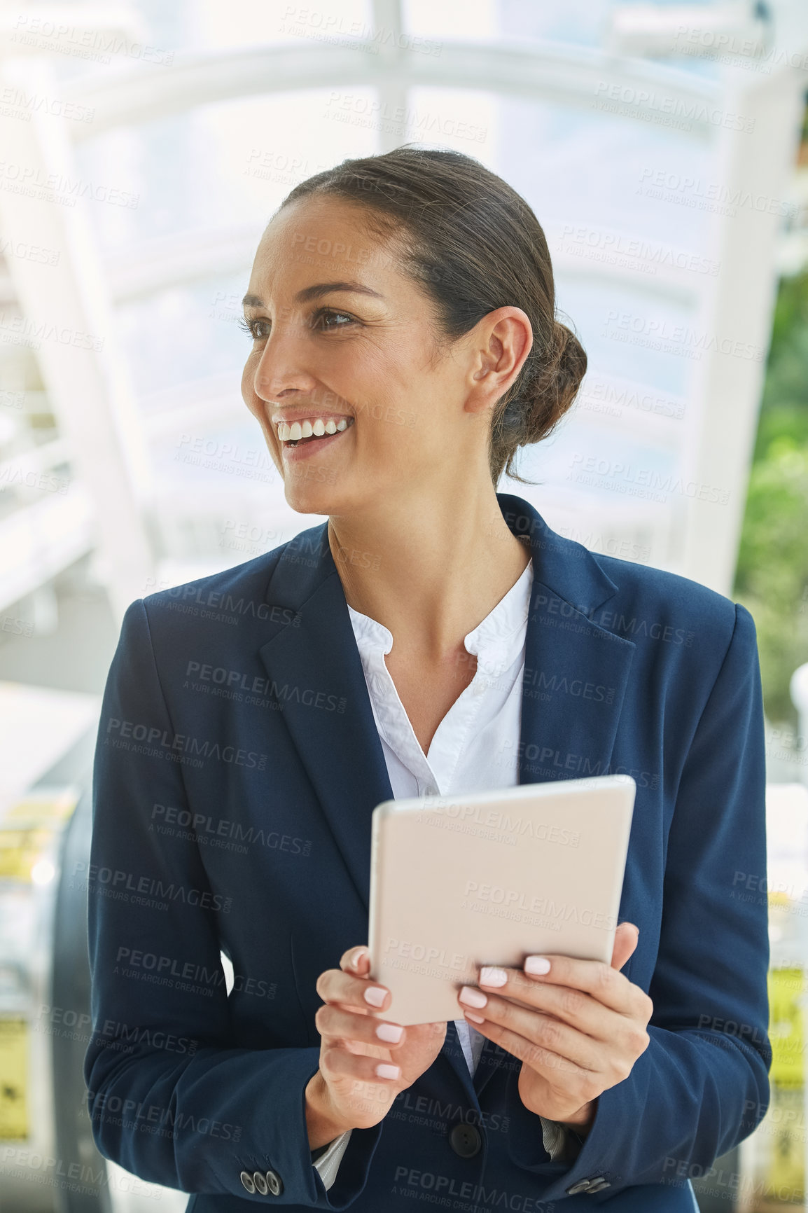 Buy stock photo Shot of a young businesswoman using a digital tablet on her way to the office