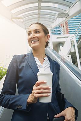 Buy stock photo Shot of a young businesswoman drinking a coffee on her way to work