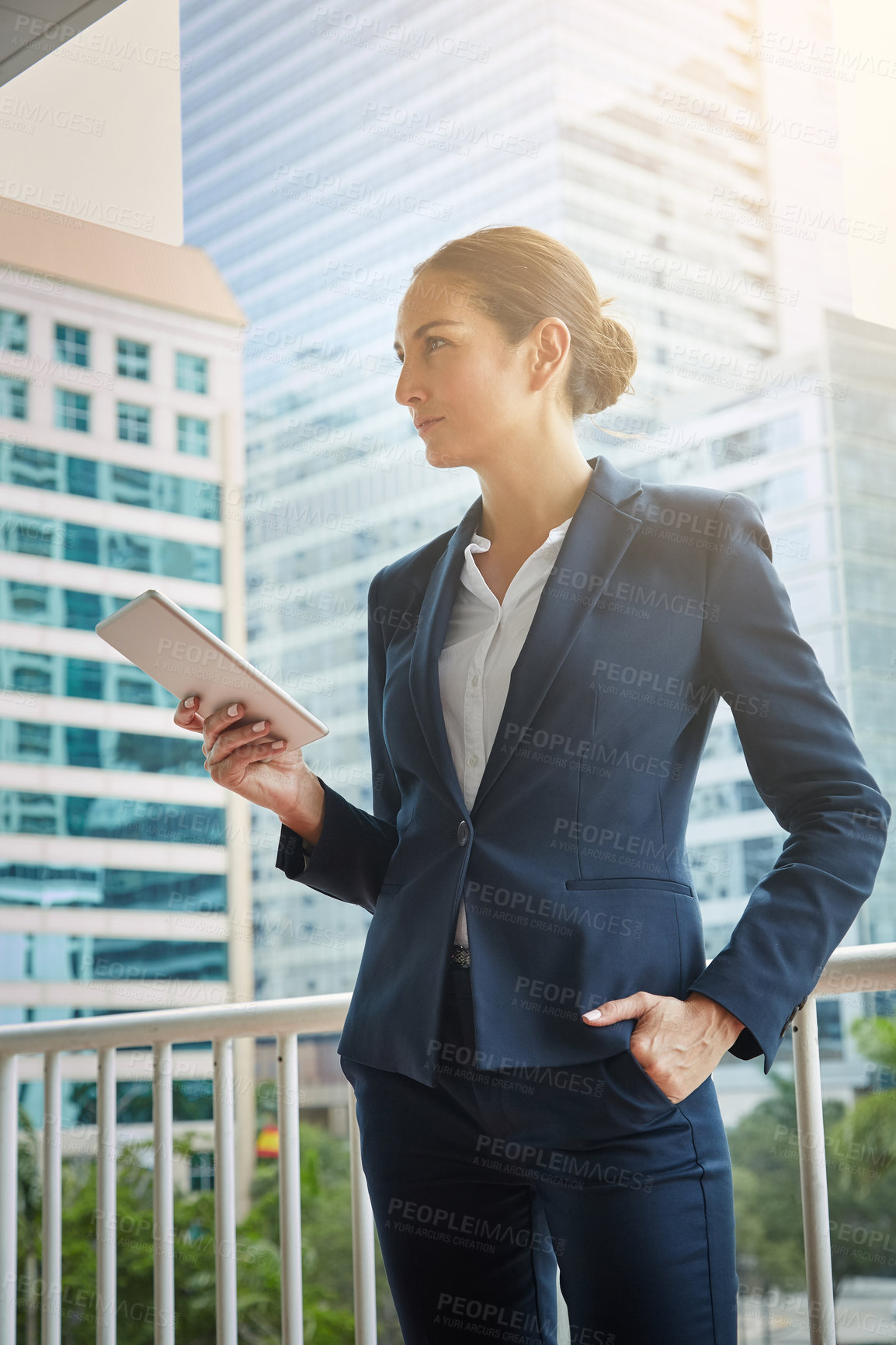 Buy stock photo Shot of a young businesswoman using a digital tablet on her way to the office