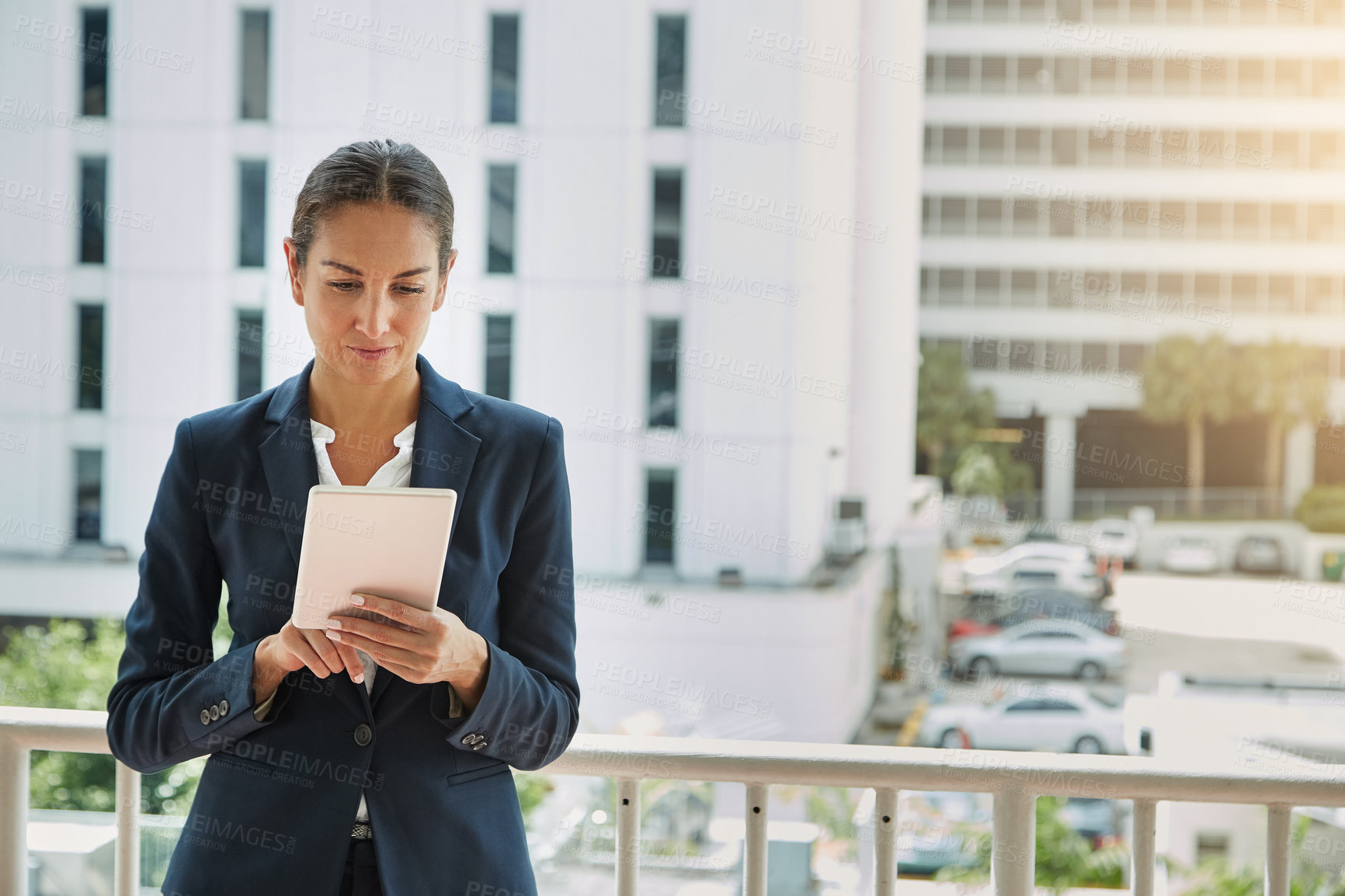 Buy stock photo Shot of a young businesswoman using a digital tablet on her way to the office