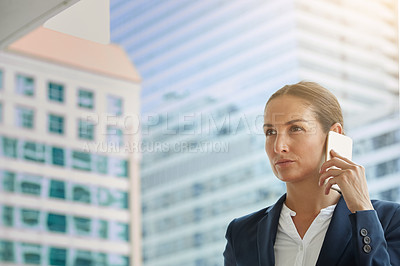 Buy stock photo Shot of a young businesswoman talking on her cellphone on the way to the office