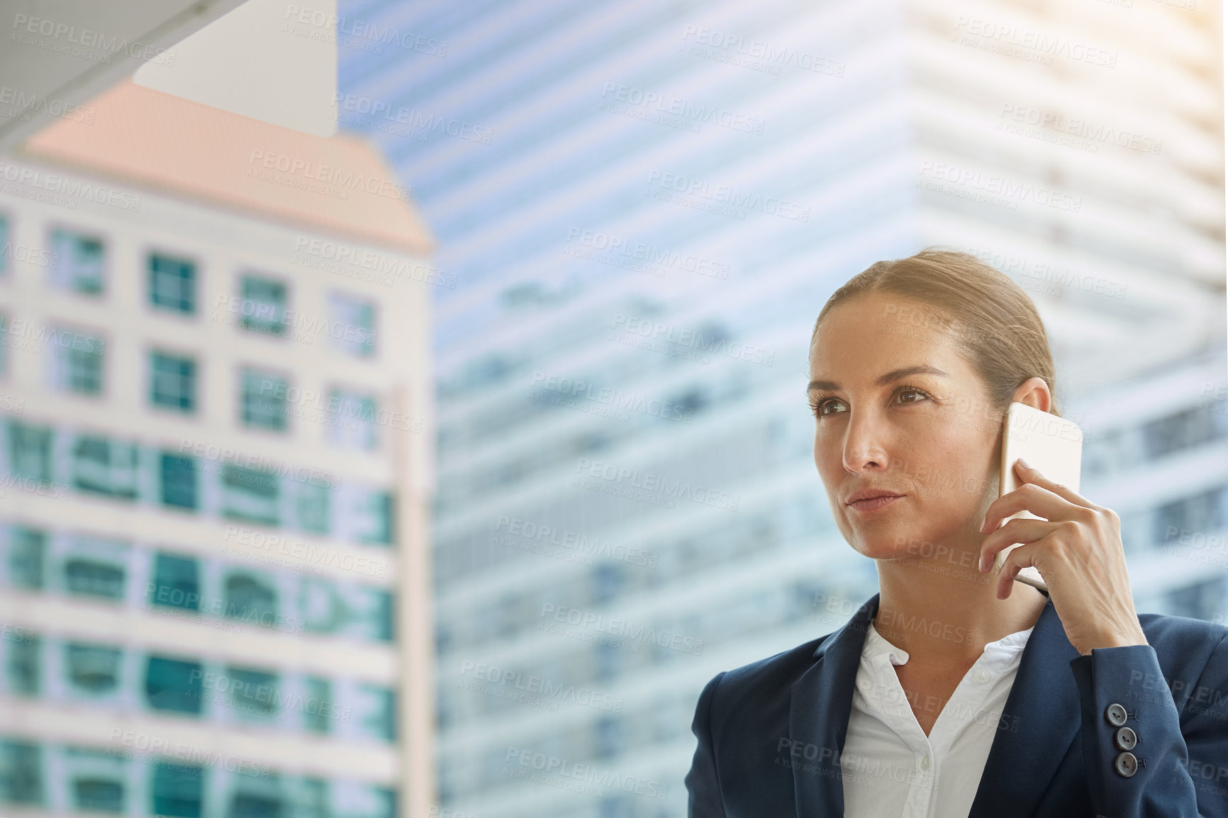 Buy stock photo Shot of a young businesswoman talking on her cellphone on the way to the office