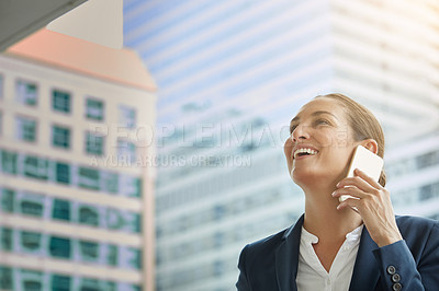 Buy stock photo Shot of a young businesswoman talking on her cellphone on the way to the office