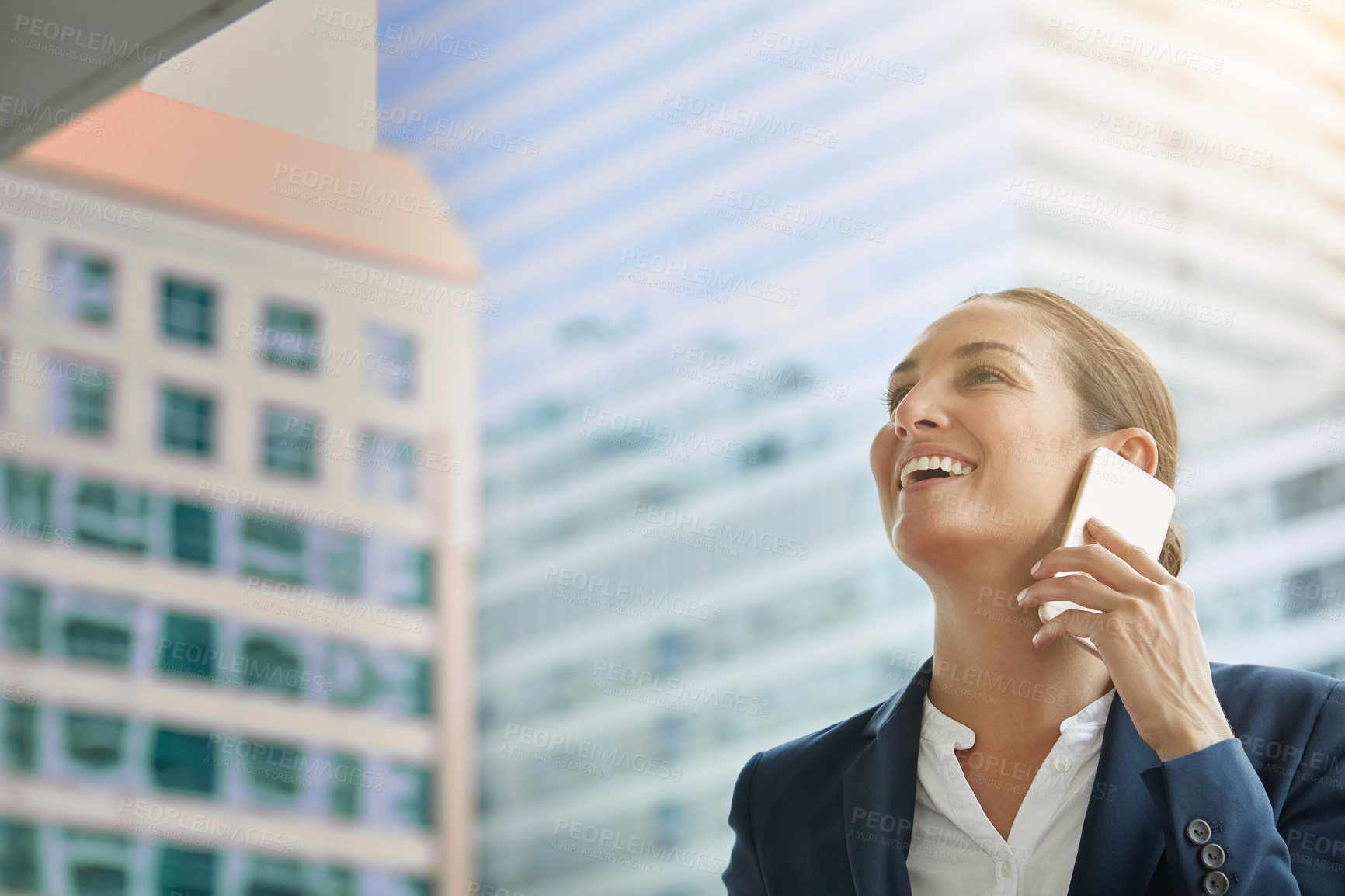 Buy stock photo Shot of a young businesswoman talking on her cellphone on the way to the office