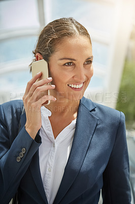 Buy stock photo Shot of a young businesswoman talking on her cellphone on the way to the office