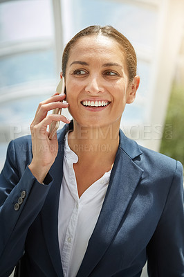 Buy stock photo Shot of a young businesswoman talking on her cellphone on the way to the office