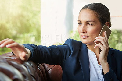 Buy stock photo Shot of a young businesswoman talking on a cellphone