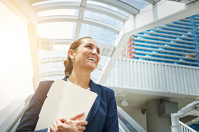 Buy stock photo Shot of a young businesswoman holding paperwork while on the way to the office