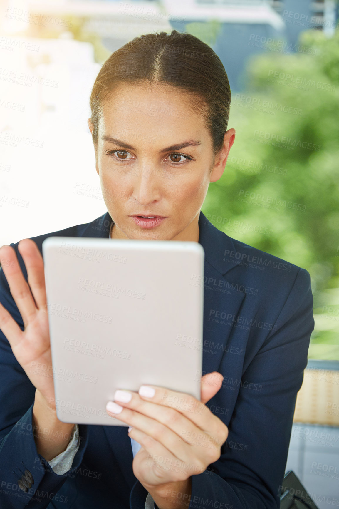 Buy stock photo Shot of a young businesswoman using a digital tablet outside