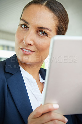 Buy stock photo Shot of a young businesswoman using a digital tablet outside