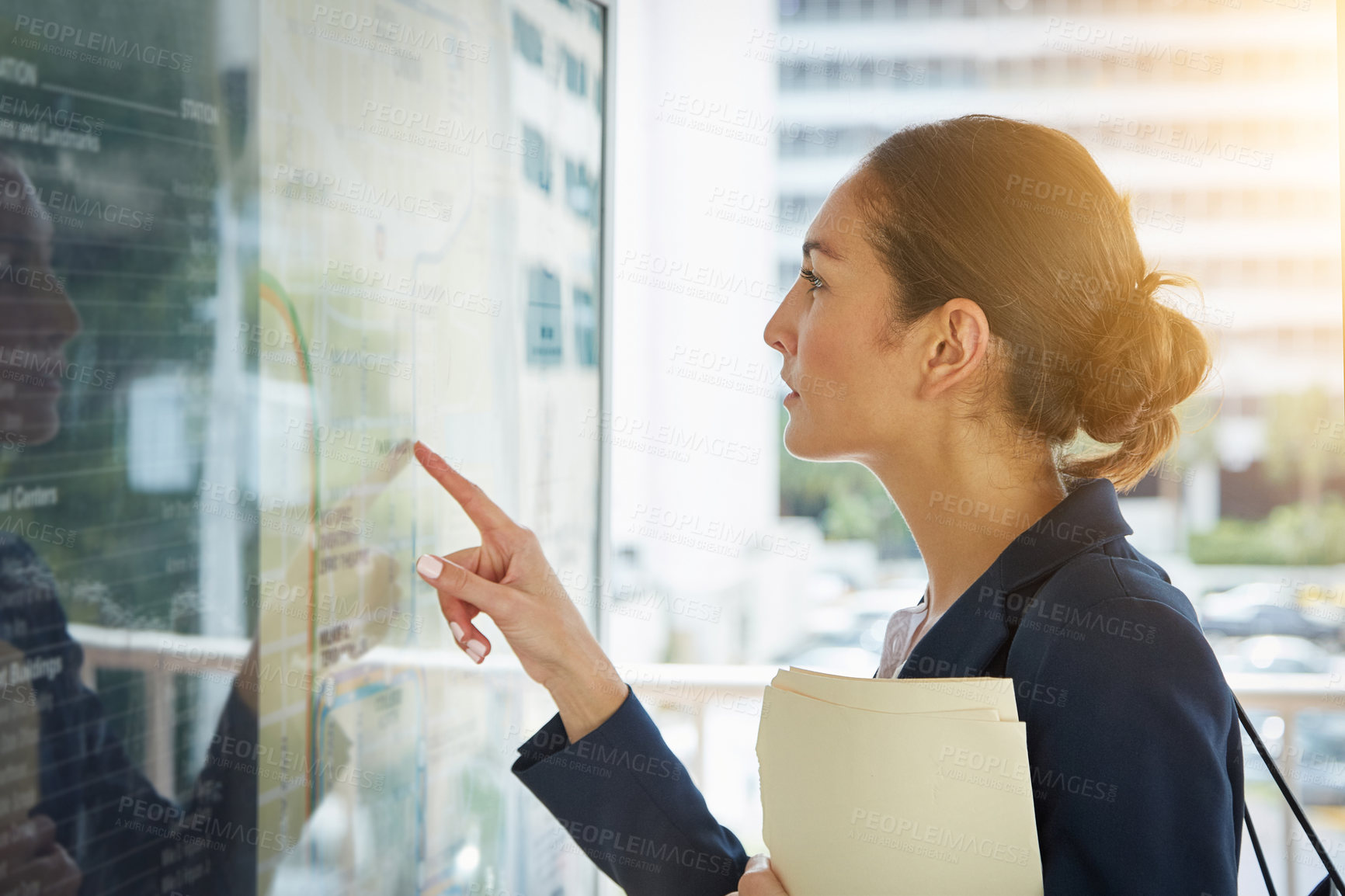 Buy stock photo Shot of a businesswoman reading a route schedule while on the way to work