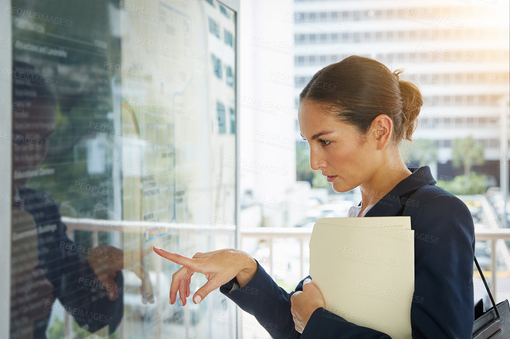 Buy stock photo Shot of a businesswoman reading a route schedule while on the way to work