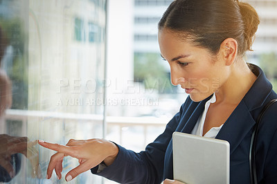 Buy stock photo Shot of a businesswoman reading a route schedule while on the way to work