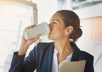 Buy stock photo Shot of a young businesswoman drinking coffee while on her way to the office