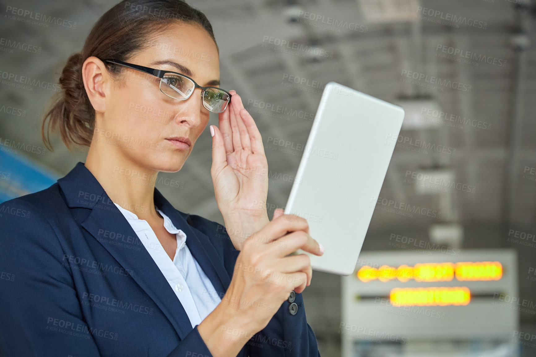 Buy stock photo Shot of a young businesswoman using a digital tablet outside