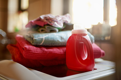 Buy stock photo Shot of a bottle of detergent and a pile of laundry on top of a washing machine