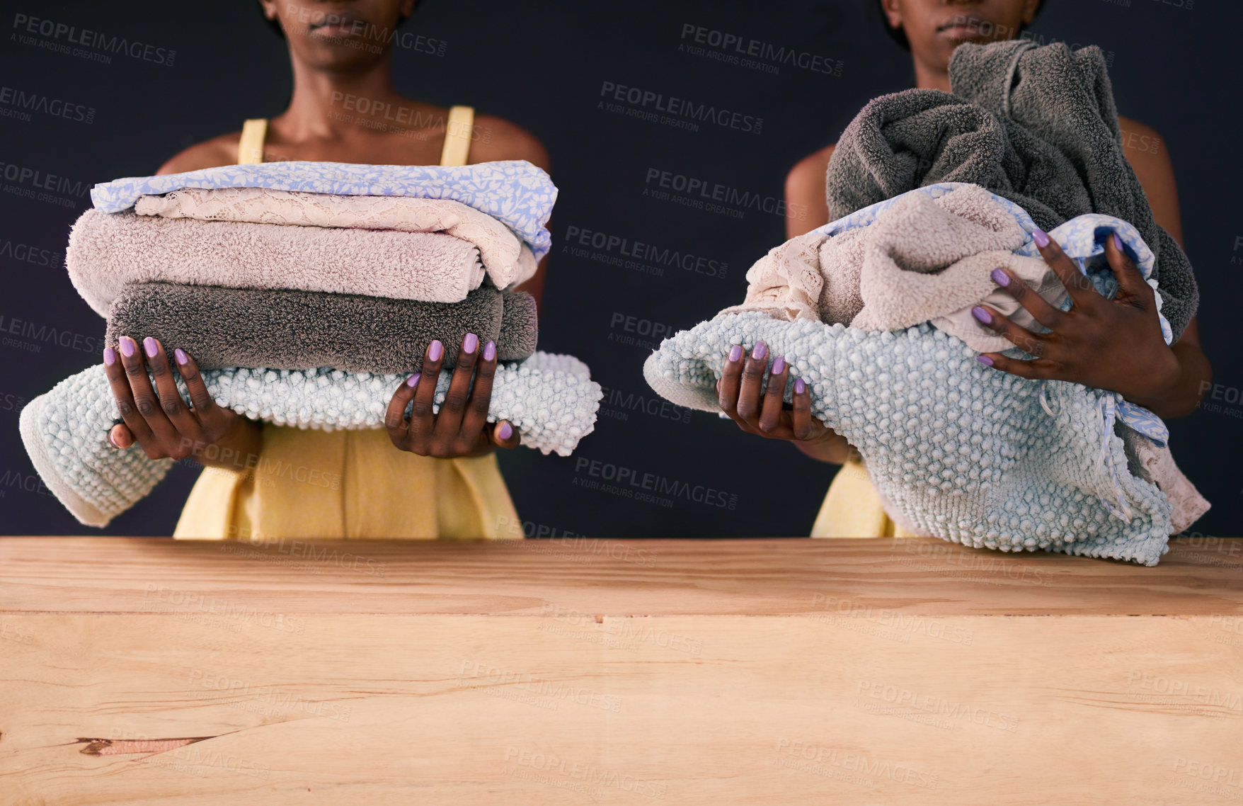 Buy stock photo Black woman, clean laundry and fresh in home with towels and weekend routine by dark background. African person, fabric care and natural detergent by wood table for house chores and cleaning clothes