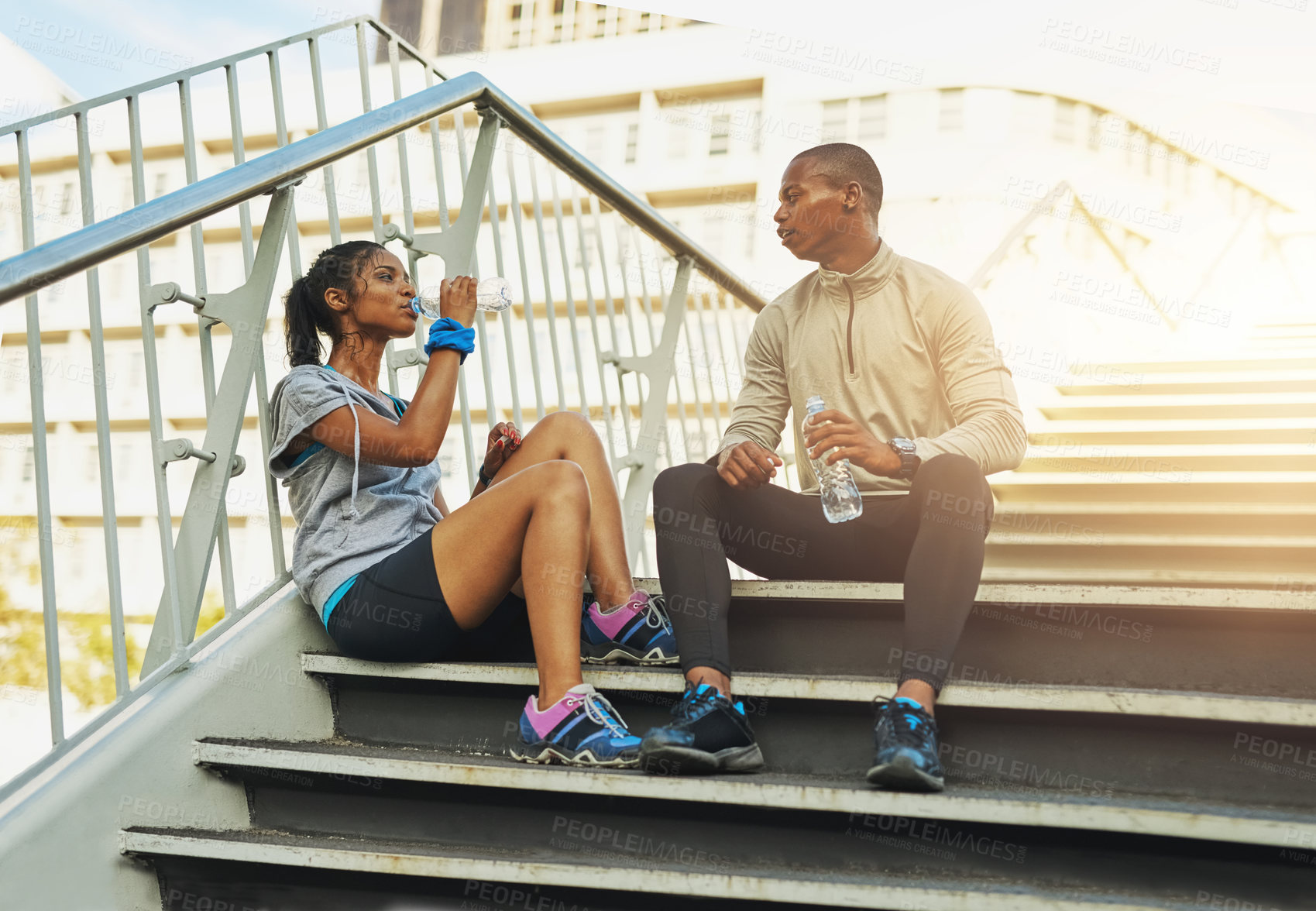 Buy stock photo Shot of a young sporty couple staying hydrated during a workout