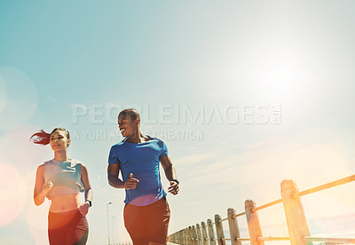 Buy stock photo Shot of a young sporty couple out for a run together