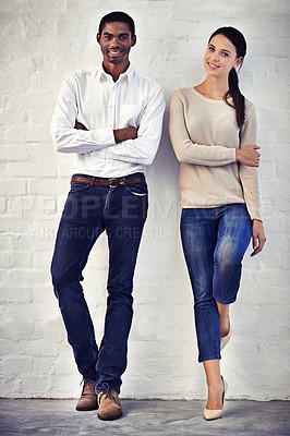 Buy stock photo Portrait of a two casually dressed friends standing side by side against a brick wall