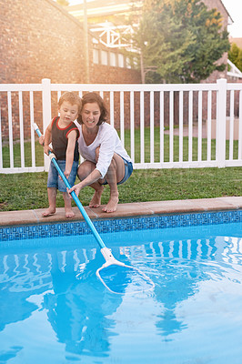 Buy stock photo Shot of a mother and son cleaning the pool together