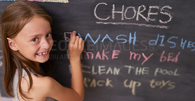Buy stock photo Portrait of a young girl marking chores off a chalkboard