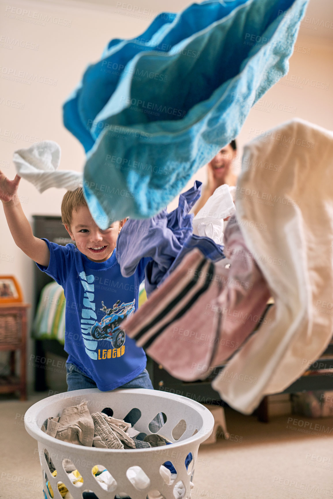 Buy stock photo Portrait of a little boy throwing laundry in the air