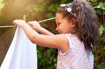 Buy stock photo Shot of a young girl hanging up laundry on a washing line