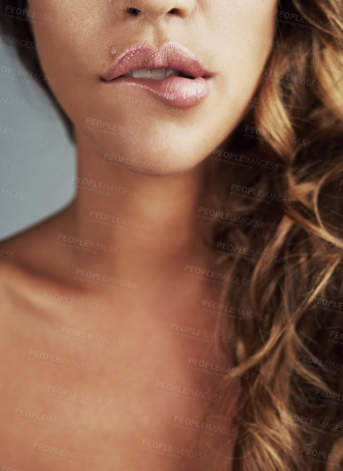 Buy stock photo Cropped shot of a young woman biting her lips