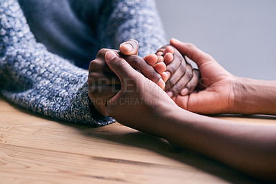 Buy stock photo Love, support and people holding hands for unity, compassion and sympathy by a wood table. Empathy, care and couple or friends with affection in an intimate bonding moment together for grief and loss