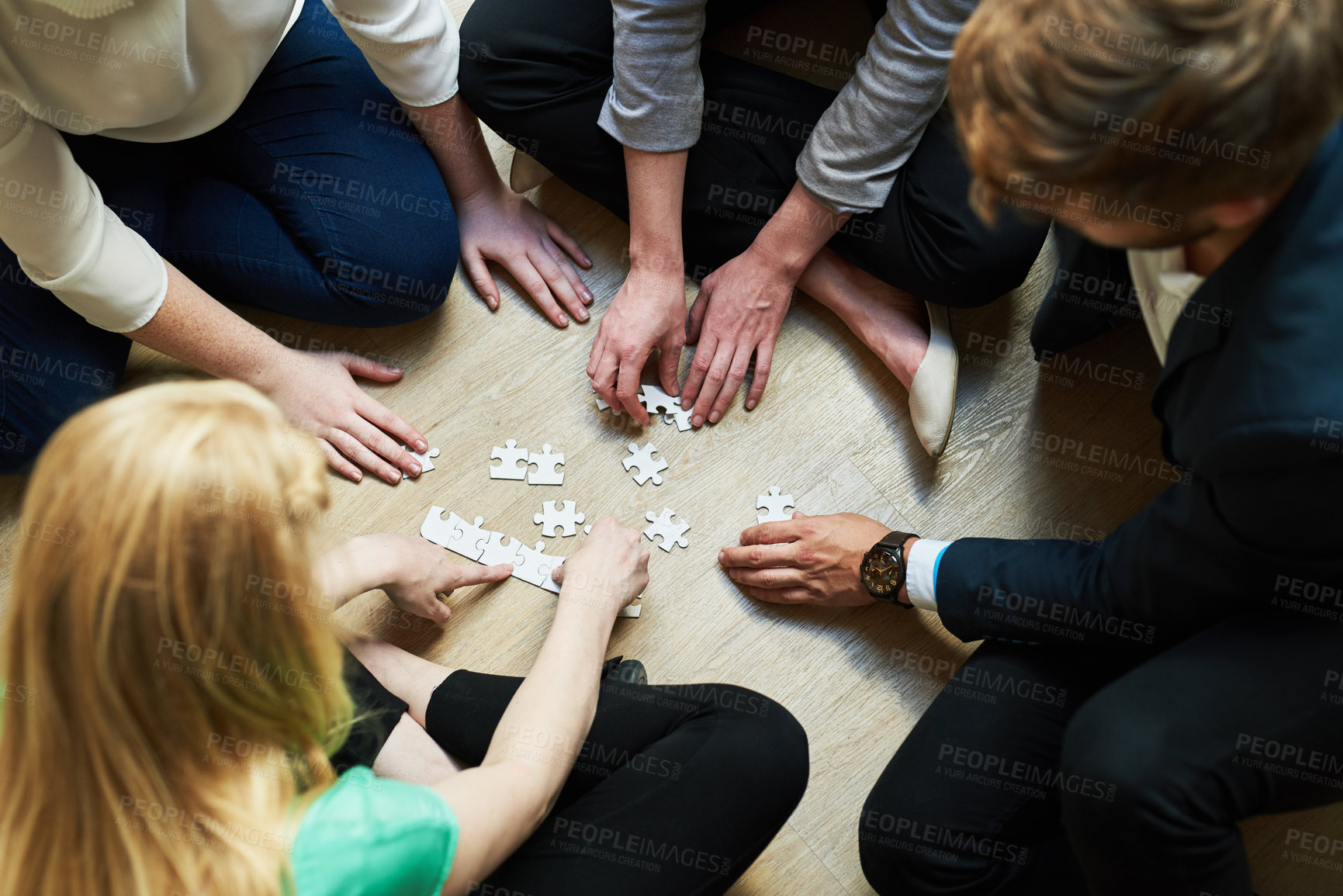 Buy stock photo Shot of a group of people putting a puzzle together