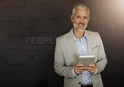 Buy stock photo Portrait of a mature businessman using a digital tablet