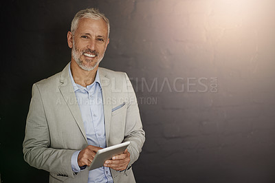 Buy stock photo Portrait of a mature businessman using a digital tablet