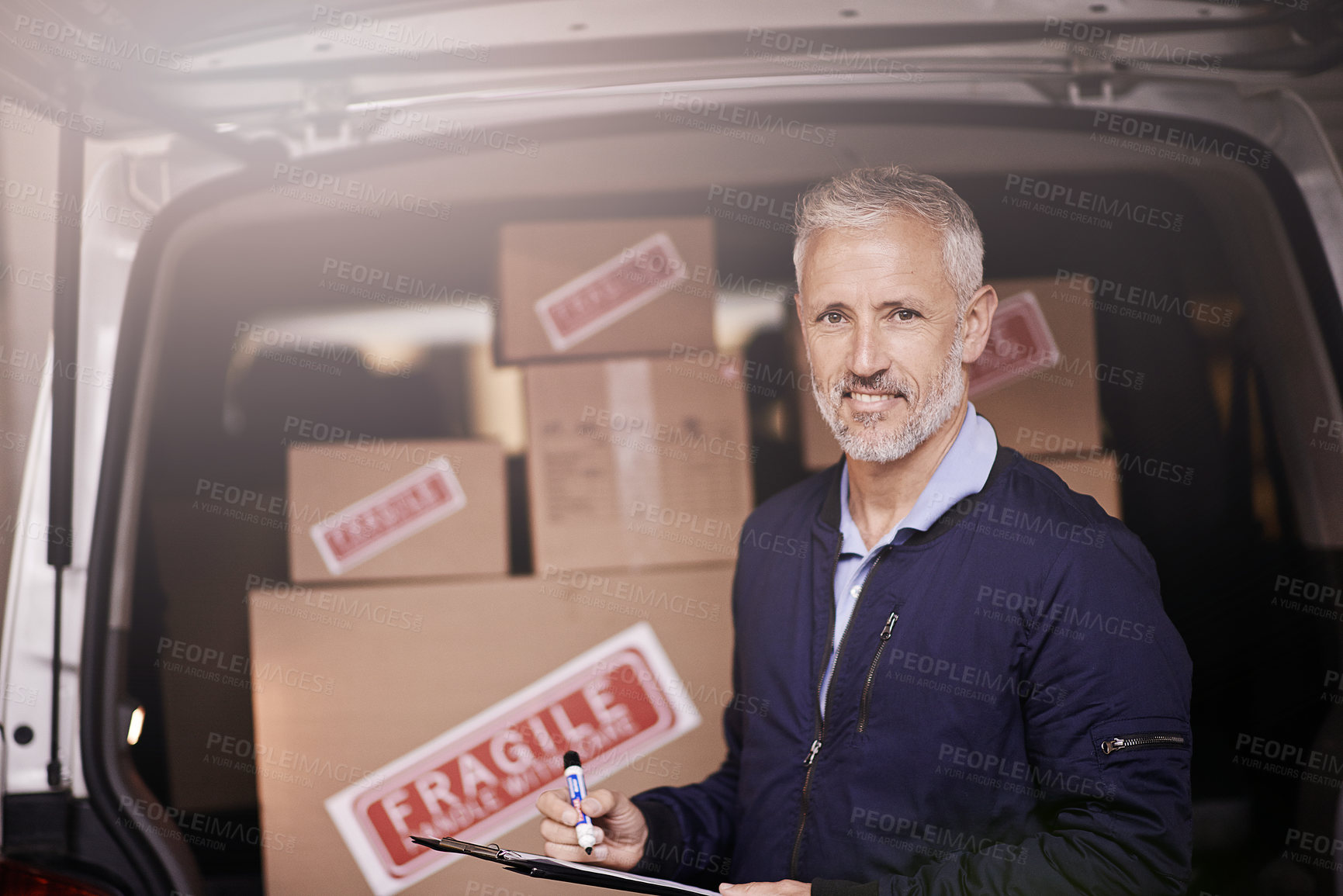 Buy stock photo Portrait of a mature delivery man standing next to a van packed with boxes