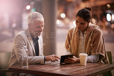 Buy stock photo Shot of businesspeople using a digital tablet together