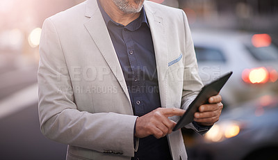Buy stock photo Closeup of a mature businessman using a digital tablet outside