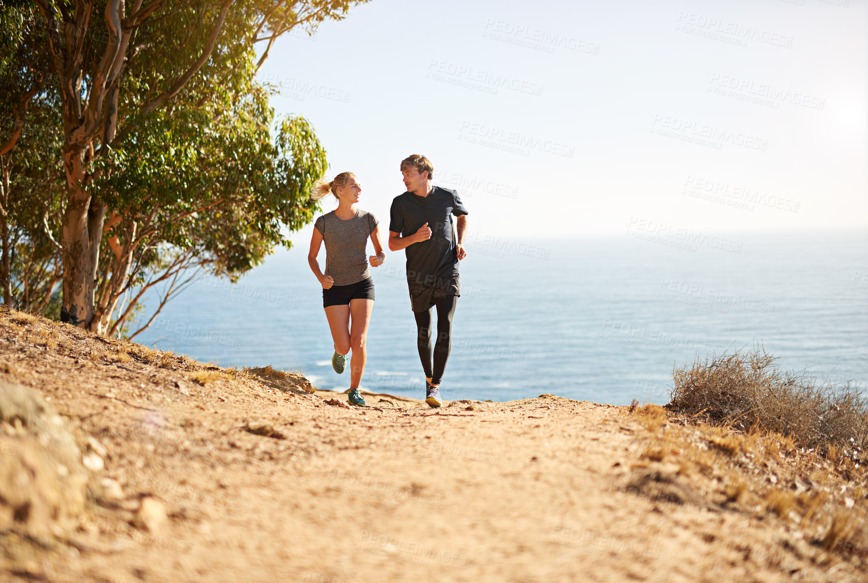 Buy stock photo Shot of a young couple trail running